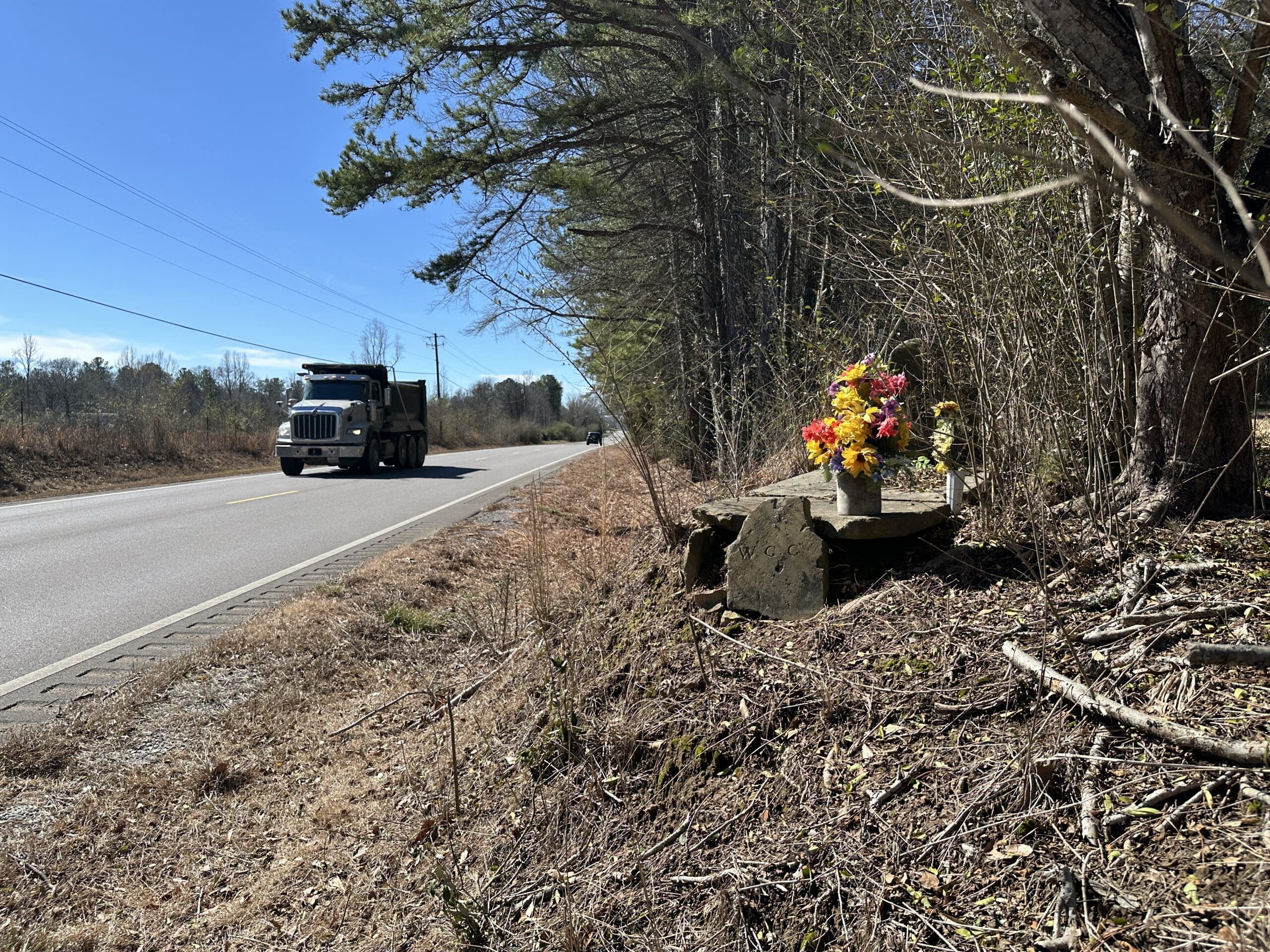 Roadside grave decorated with flowers.