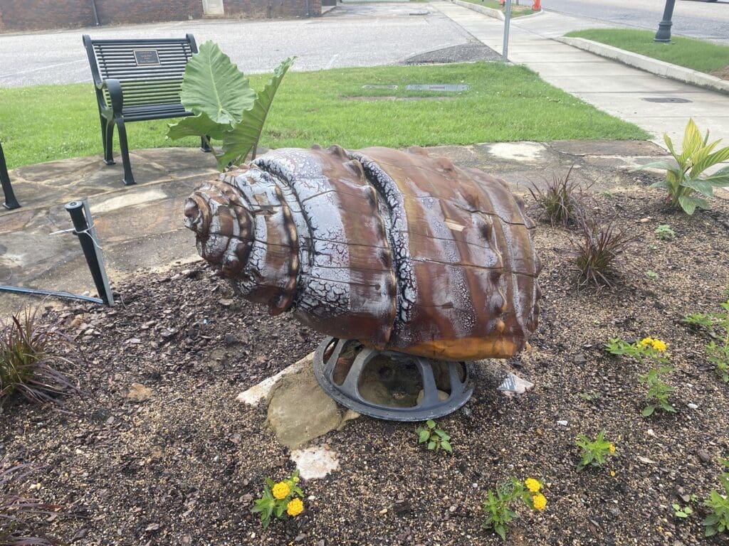 Large wood carving of a river snail.