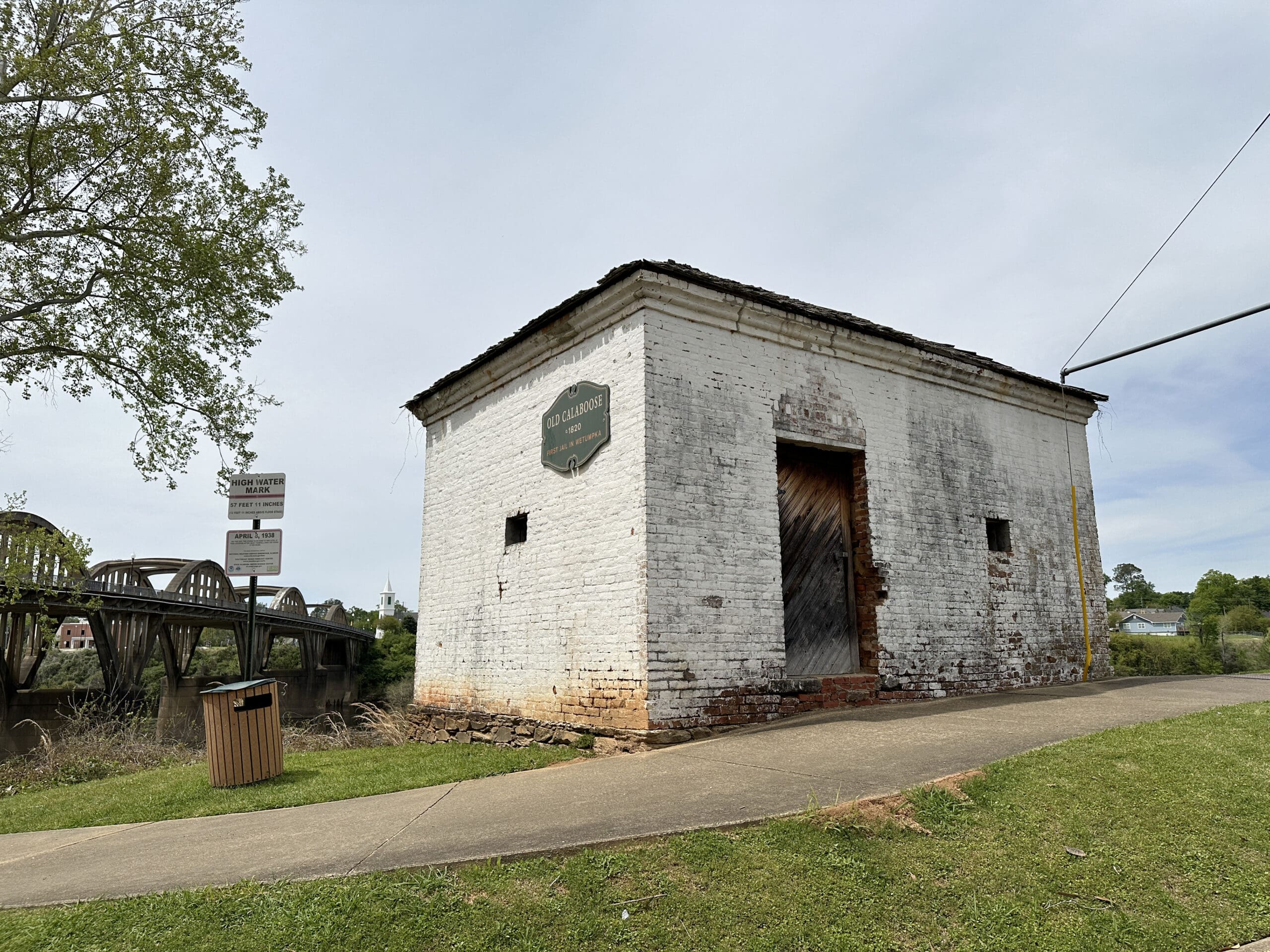 An 1820 brick jail, "The Old Calaboose", in Wetumpka, AL. The concrete Bibb-Graves bridge is visible in the background.