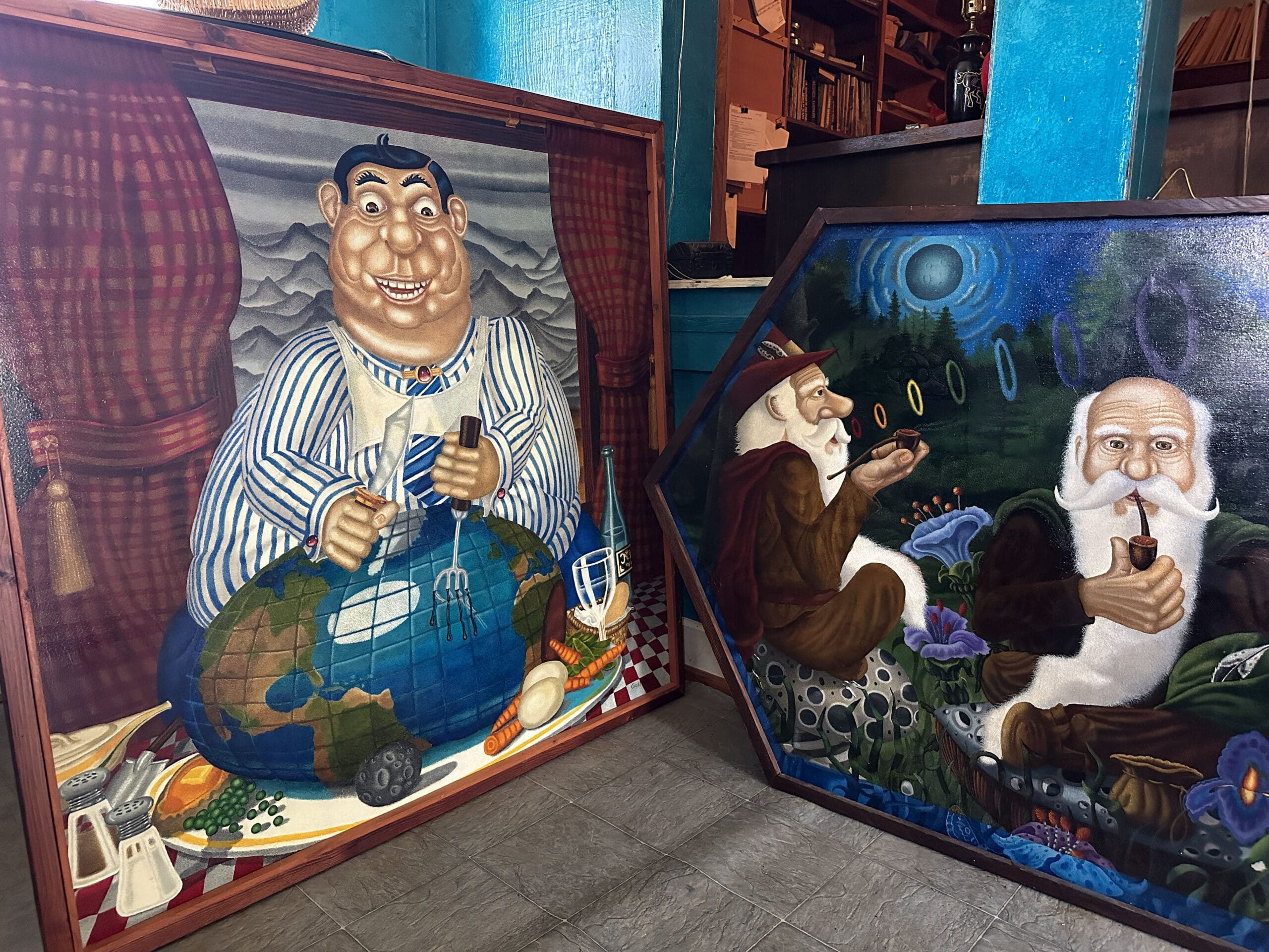 Two colorful paintings featuring (at left) an overweight white man hungrily cutting into the globe with a fork and (at right) two gnomes smoking pipes while one blows out smoke rings of various colors.